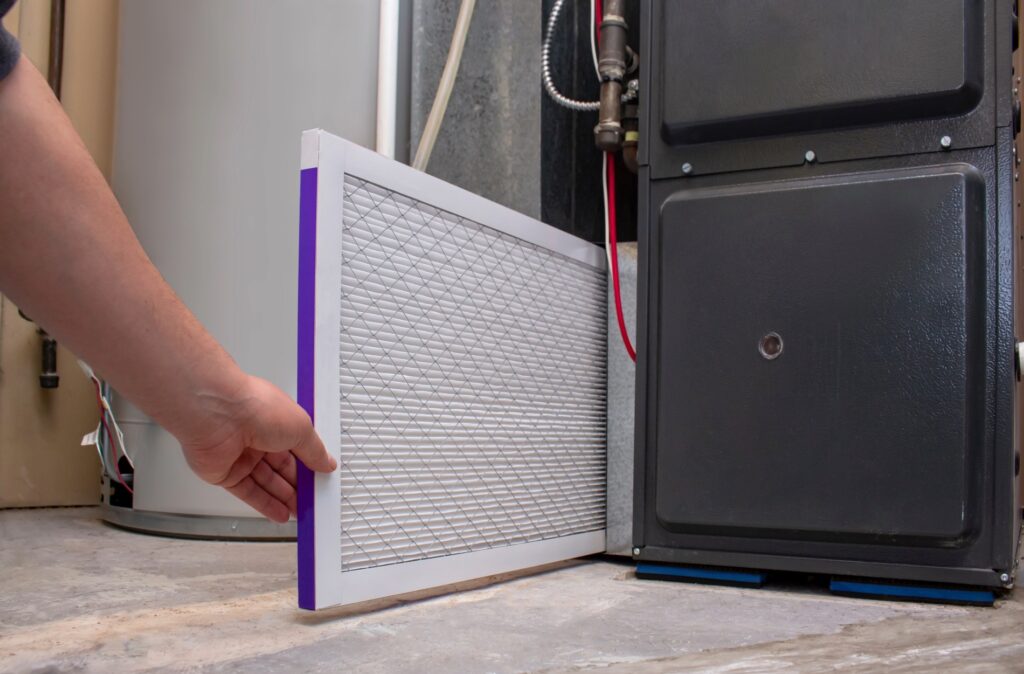 A man operates a filter to purify a furnace, ensuring optimal performance and cleanliness in the heating system.